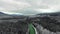 Drone shot of dense pine forest, a running river and snow-capped mountains in the fog