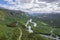 Drone shot of greenery wetland with mountains and blue cloudy sky