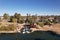 Drone shot of a lake in Gilbert Park with palms and trees under blue sky on a sunny day