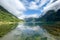 Drone shot of the lake surrounded by cloud-covered green hills at Geiranger Fjord, Norway