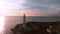 Drone shot lighthouse beach lighthouse sunset. Lighthouse on a background of beautiful sunset.