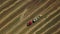 Drone shot of making hay cubes with tractor. Agricultural machinery ejecting bale of hay in a sunny day.