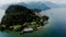 Drone shot over Como lake with view of Bellagio town and forested hill