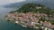 Drone shot over Como lake with view of Bellagio town and forested hill