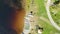 Drone shot over lake and canoes on a green shoreline