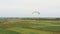 Drone shot Of Paramotor Tandem Flying over the green fields