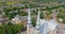 Drone shot rotating high above the bells of the church showing the surrounding village and landscape