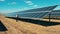 Drone shot of a solar panel technician inspecting solar panels in a solar park