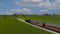 Drone Side, Behind View of a Antique Steam Passenger Train Approaching Around a Curve Thru Farmlands