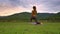 Drone Side View Girl Holds Yoga Pose on Knee at Lake Meadow