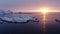 Drone sideway move video of fishing boat sailing on fishing during sunrise in arctic lofoten islands. sunlight and snow mountains.