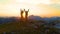 DRONE: Stunning golden sunrise shines on the mountains and excited man and woman