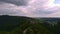 Drone takes off among the trees and reveals a castle on top of the mountain