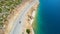 DRONE: Tourists in SUV cruise along the ocean during a road trip in Greece.