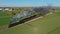 Drone Traveling Ahead of View of a Steam Passenger Train Blowing Lots of Smoke and Steam