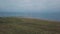 Drone video capturing from top sea side with a green field , three people ride a horse beside the beach.