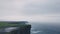 Drone video capturing tourist on the top of amazing stones view cliffs of moher , traveling people around visiting the