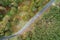 Drone view. Aerial zenith view of a mountain road with a pine forest on one side and an oak forest on the other side.