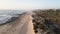 Drone view of a beautiful sandy beach large stones, wooden bridges and paths, railway and houses in small town Espinho