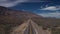 Drone view of desert asphalt road with scenic rocky mountain
