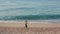 Drone view of fit woman runner training on beach