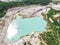 Drone view on a flooded kaolin quarry with turquoise water and white shore. Aerial shot of a kaolin pit flooded with water