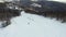 Drone view of a group of snowboarders descending the ski slopes.