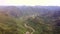 Drone View Hilly Landscape with Jungle and Meandering Road