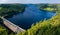 Drone view of a huge lake surrounded by rural farmland and forest. Lake Vyrnwy, Wales