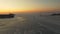 Drone view of the ice-bound strait with tugboats operating at sunset