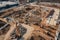 Drone view of a large construction site with numerous workers and heavy machinery in operation