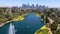 Drone view of  Los Angeles city skyscrapers in the background with fountain in a lake at Echo Park