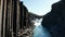 Drone view of majestic canyon with volcanic basalt columns in Iceland and glacier water river streaming. Birds eye view