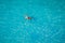 Drone view of a man floating in tropical sea water. Aerial view of young man floating on sea water enjoying sunbathing and