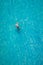 Drone view of a man floating in tropical sea water. Aerial view of young man floating on sea water enjoying sunbathing and