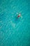 Drone view of a man floating in tropical sea water. Aerial view of young man floating on sea water enjoying sunbathing and