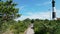 Drone view moving over the boardwalk leading to the Fire Island Lighthouse