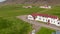 Drone view orbit around Iceland flag waving out of typical building in Iceland highland. The flag of Iceland fluttering