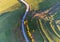 Drone view, passing cars on asphalt road trough agricultural fields