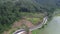 Drone view of the road between green forests and the Serayu river in Indonesia