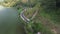 Drone view of the road between green forests and the Serayu river in Indonesia