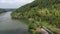 Drone view of the road between green forests and the Serayu river in Indonesia