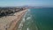 Drone view of San Juan Alicante buildings and sand beach by splashing sea waves in Spain