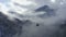 Drone view ski lift moving over fogy woodland on winter resort. Aerial landscape ski elevator transporting sportsmen between snowy