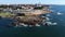 Drone view of a stone cape in the Atlantic Ocean with Porto in the background.