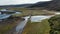 Drone view vehicle speeding on dust road in Iceland exploring amazing landscape. Aerial view off road 4x4 car driving