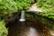 Drone view of a waterfall and pool in a narrow canyon and green forest Sgwd Gwladys, Brecon Beacons, Wales