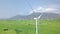 Drone view wind power station in green field on mountain landscape. Windmill turbine, generating wind power aerial view