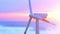 Drone view of wind turbine spinning against magenta sunrise
