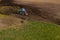Drone view of working agricultural tractor in field during summer day